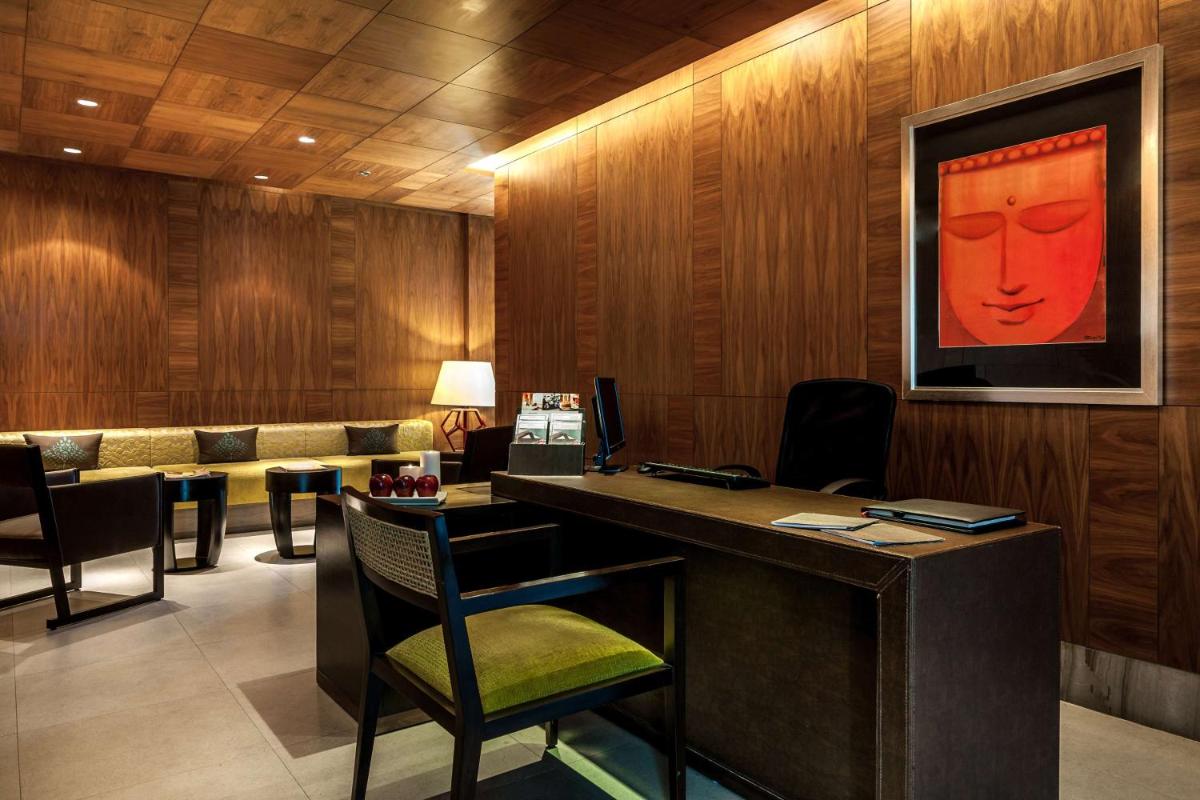 a lobby with a desk with a red face on the wall at Hyatt Ahmedabad in Ahmedabad
