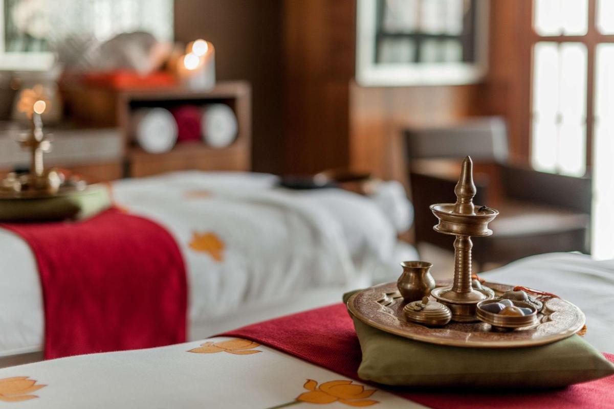 a room with two beds and a table with a tray with candles at Hyatt Ahmedabad in Ahmedabad