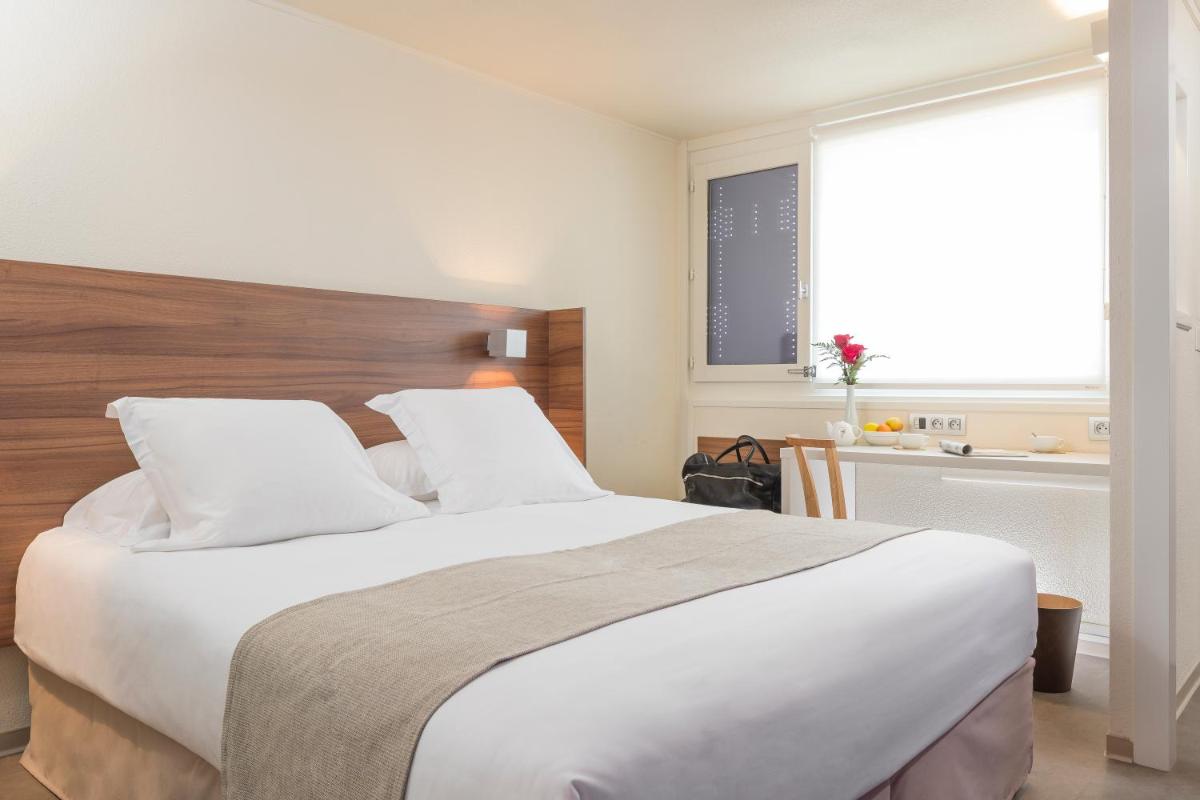 une chambre avec un grand lit blanc et une fenêtre dans l'établissement Terre de Provence Hôtel & Spa, au Pontet