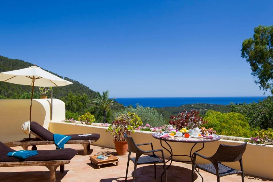 Un patio con mesa y sillas y el mar. en Agroturismo Can Talaias San CArlos, en Sant Carles de Peralta