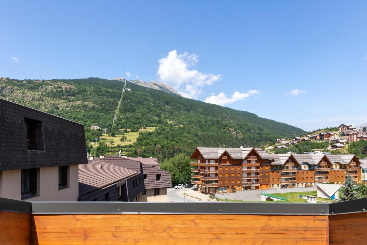 - une vue sur un complexe avec une montagne en arrière-plan dans l'établissement SOWELL HOTELS Le Parc & Spa, à Briançon