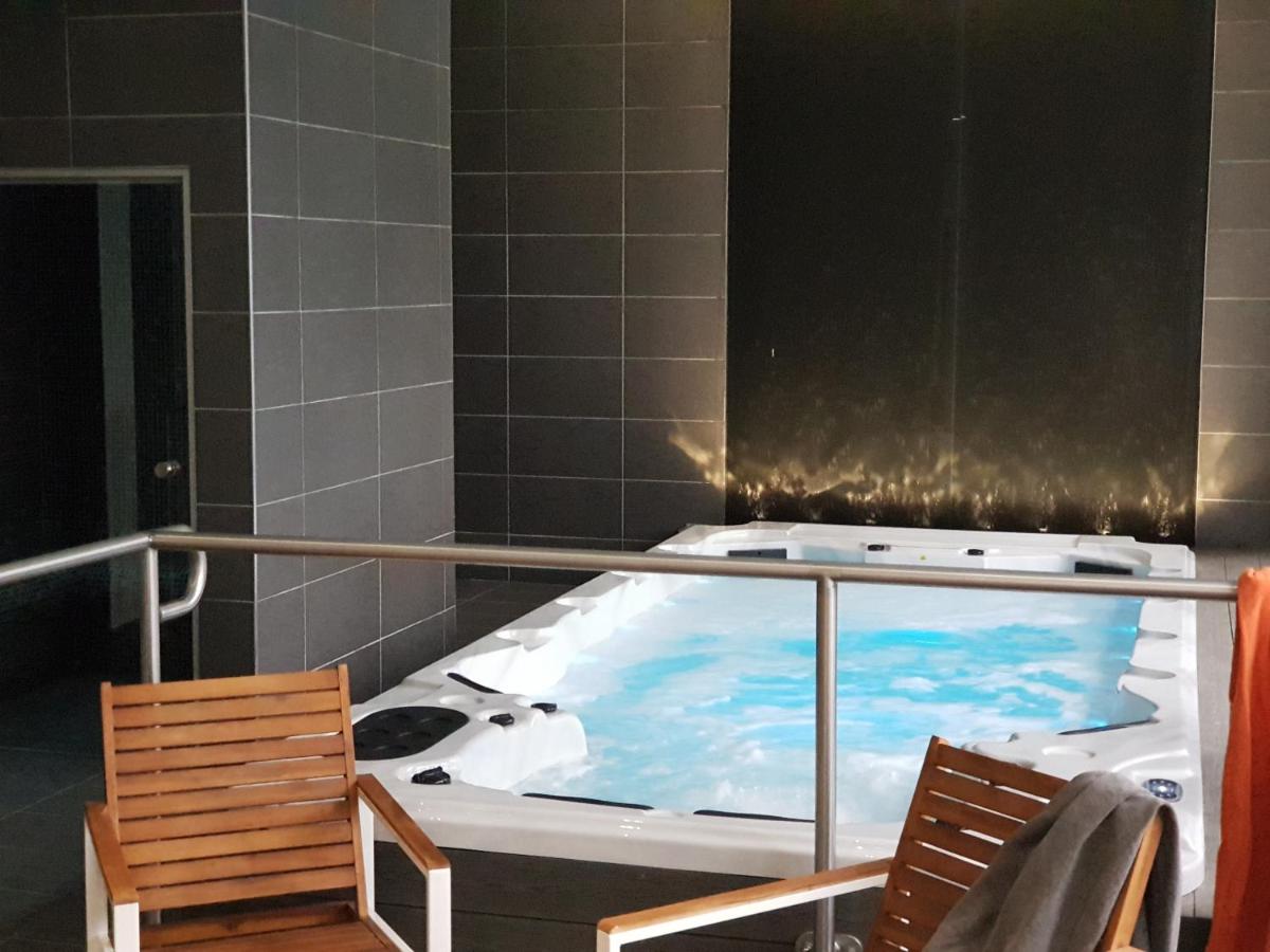 La salle de bains est pourvue d'une baignoire et de 2 chaises. dans l'établissement Le Castelet, à Le Mont-Dore