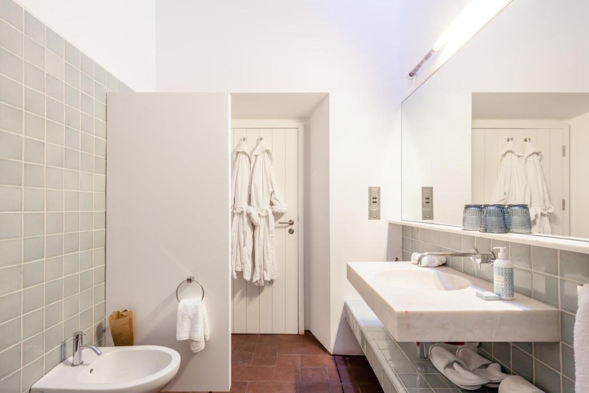 um banheiro branco com duas pias e um espelho em Torre de Palma Wine Hotel, Monforte, a Member of Design Hotels em Monforte