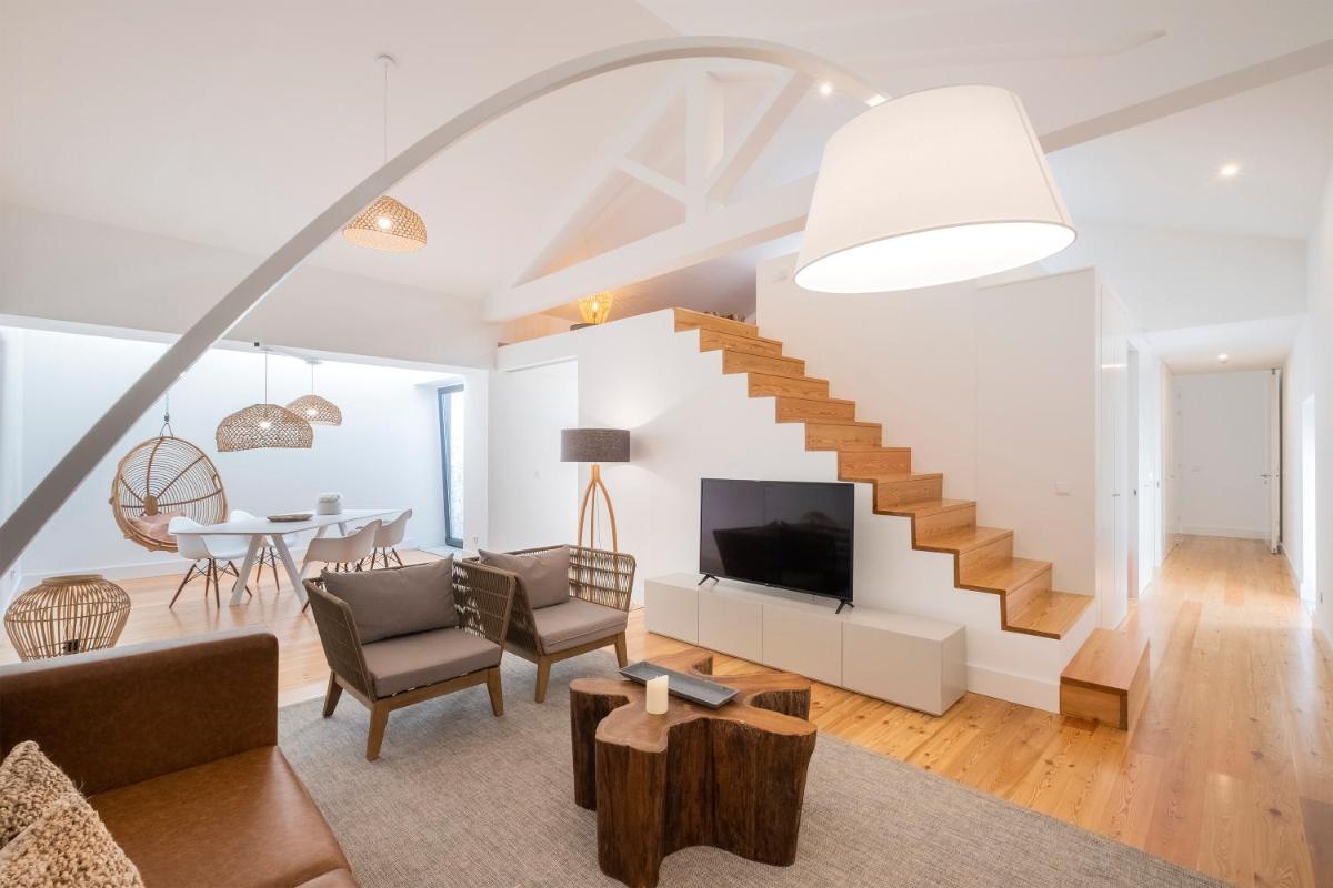 uma sala de estar com uma escada e uma mesa em Aqua - Pópulo Eco Village em Ponta Delgada