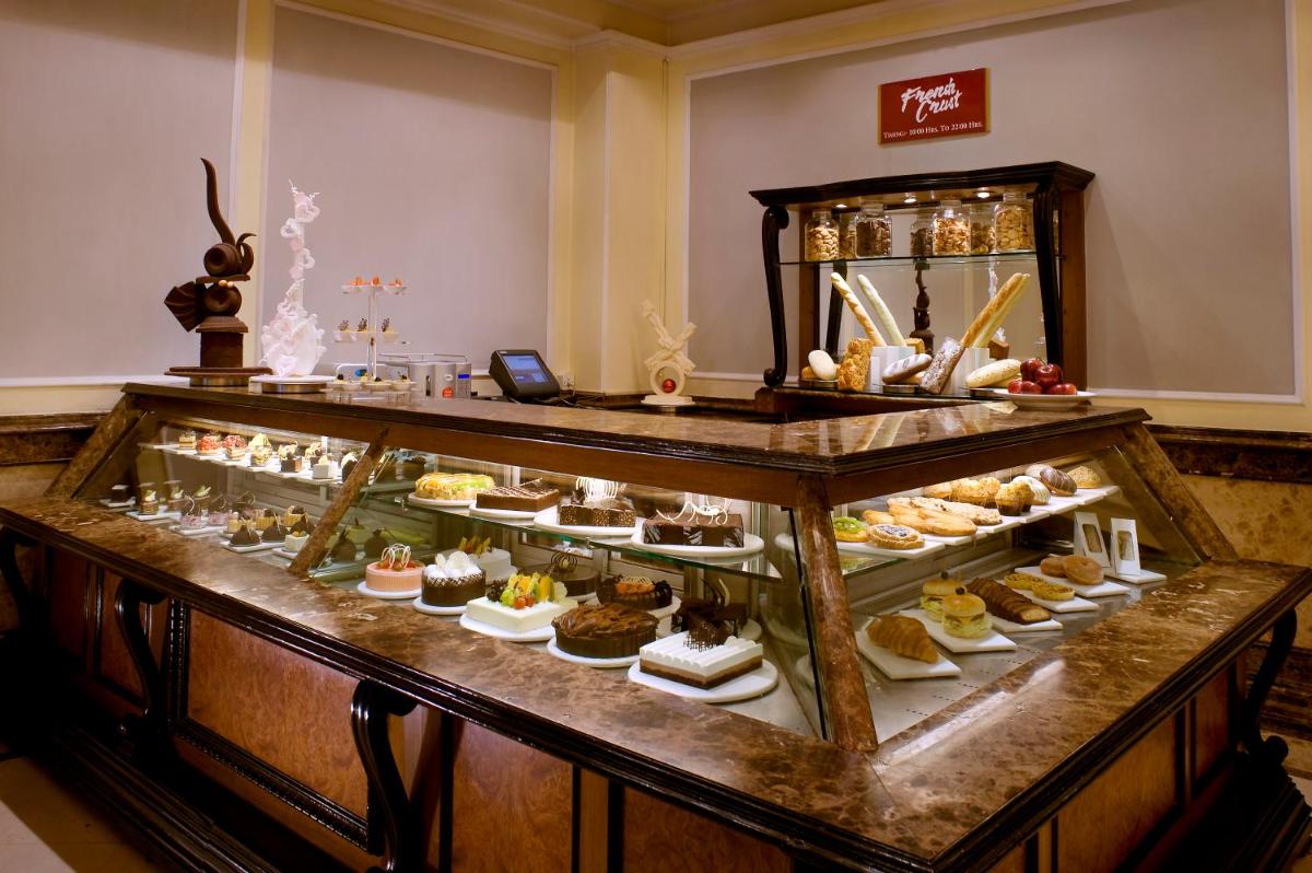 a display case filled with different types of desserts at The Suryaa New Delhi in New Delhi a display case filled with different types of desserts at The Suryaa New Delhi in New Delhi