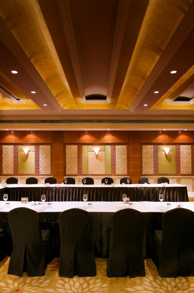 a large meeting room with a large table and chairs at The Suryaa New Delhi in New Delhi a large meeting room with a large table and chairs at The Suryaa New Delhi in New Delhi