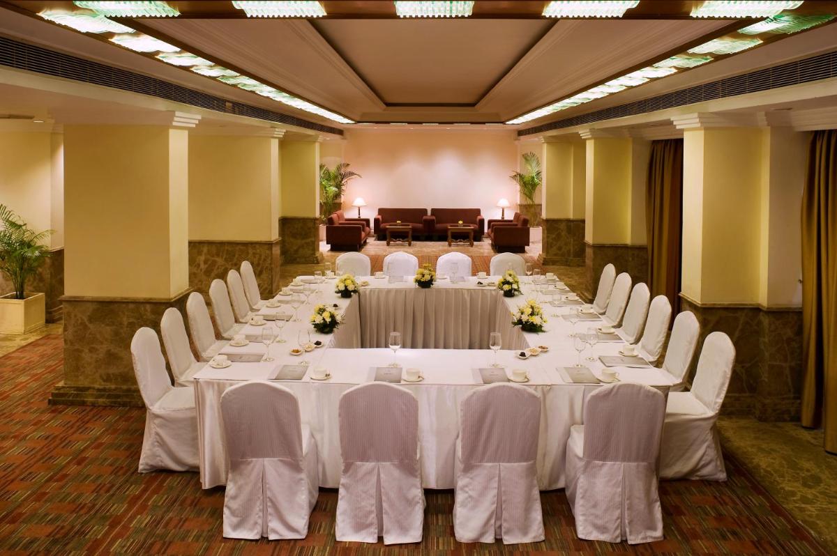a large banquet hall with white tables and chairs at The Suryaa New Delhi in New Delhi a large banquet hall with white tables and chairs at The Suryaa New Delhi in New Delhi