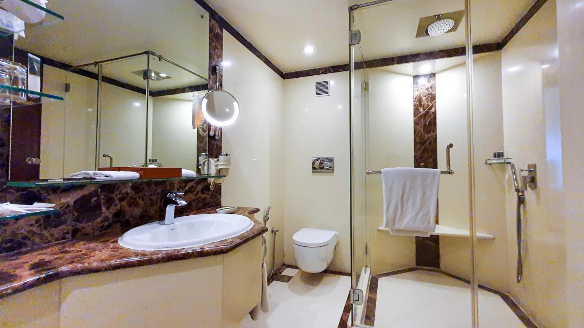 a bathroom with a sink and a shower and a toilet at The Orchid Hotel Mumbai Vile Parle in Mumbai