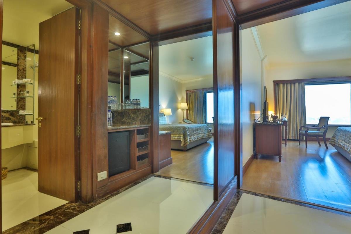 a living room with a bedroom and a bed at The Orchid Hotel Mumbai Vile Parle in Mumbai a living room with a bedroom and a bed at The Orchid Hotel Mumbai Vile Parle in Mumbai
