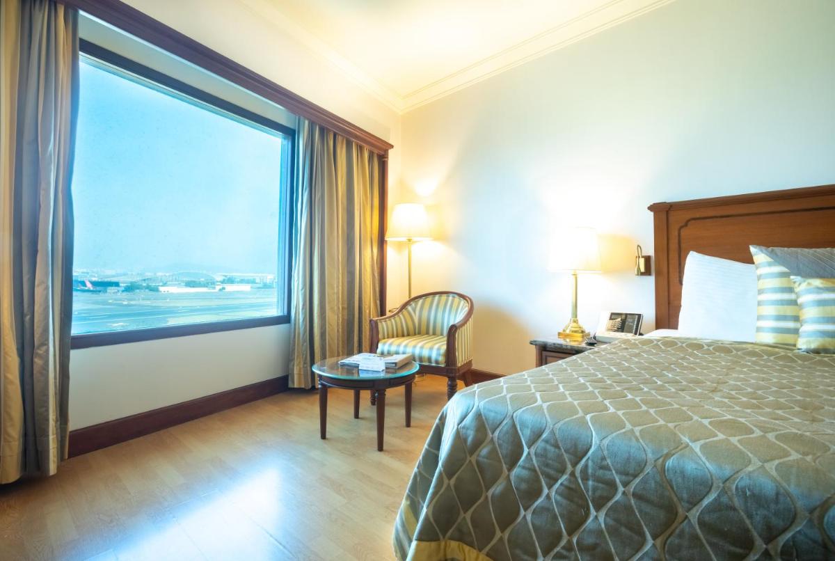 a hotel room with a bed and a large window at The Orchid Hotel Mumbai Vile Parle in Mumbai