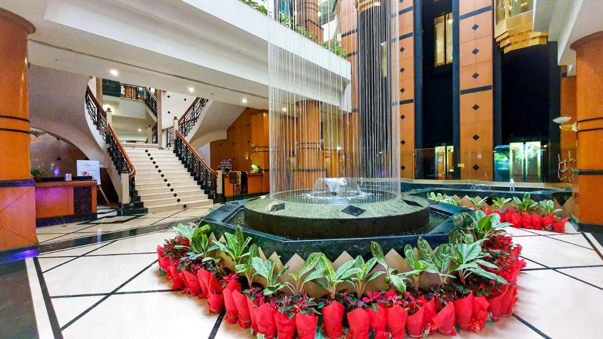 a lobby with a large fountain with red flowers at The Orchid Hotel Mumbai Vile Parle in Mumbai