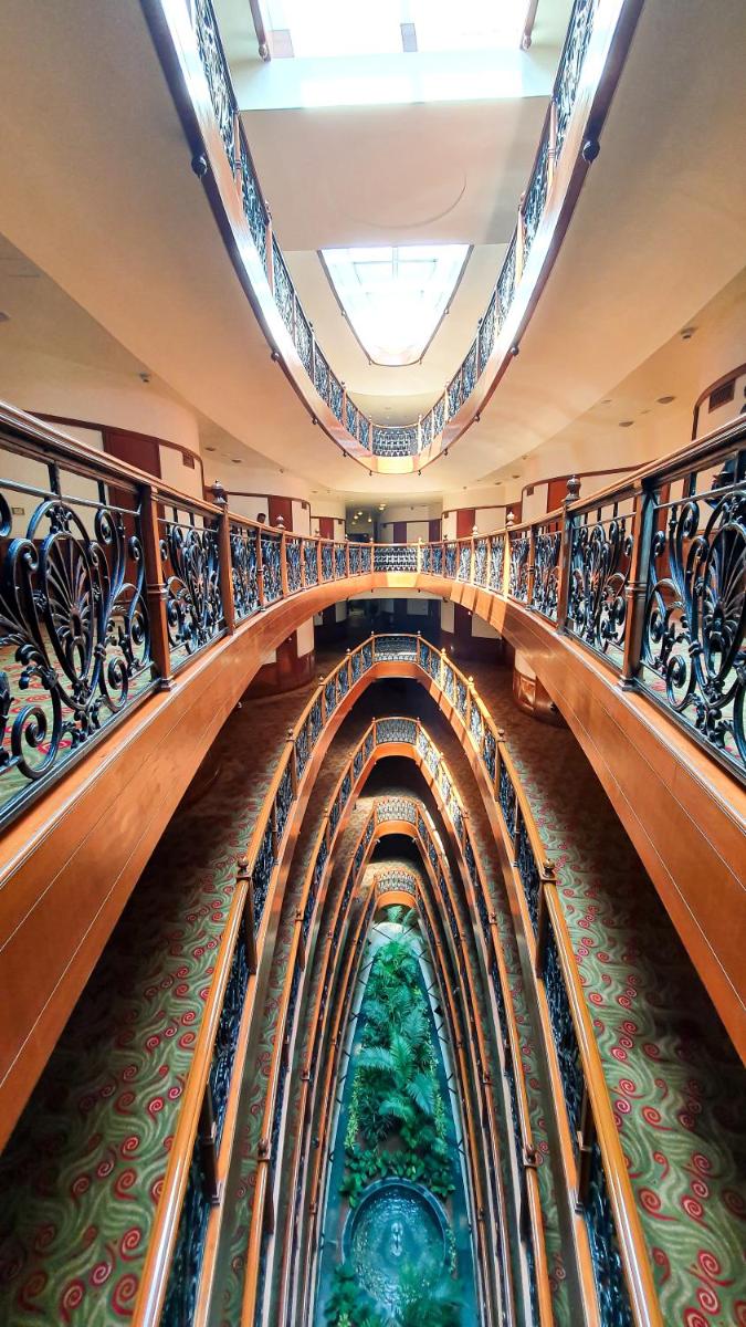 a long escalator in a building with stained glass at The Orchid Hotel Mumbai Vile Parle in Mumbai