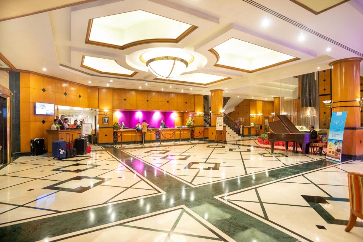 a lobby with a piano and a dance floor at The Orchid Hotel Mumbai Vile Parle in Mumbai