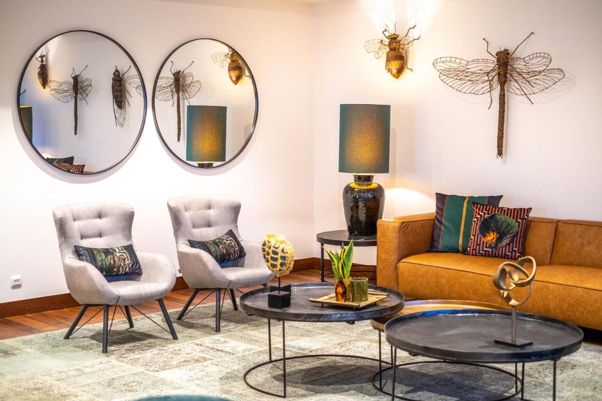 uma sala de estar com espelhos e um sofá e cadeiras em Monte Real - Hotel, Termas & Spa em Monte Real