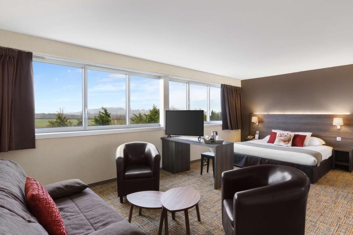 une chambre d'hôtel avec deux lits et une télévision dans l'établissement Best Western Plus Hotel Admiral, à La Tour-de-Salvagny