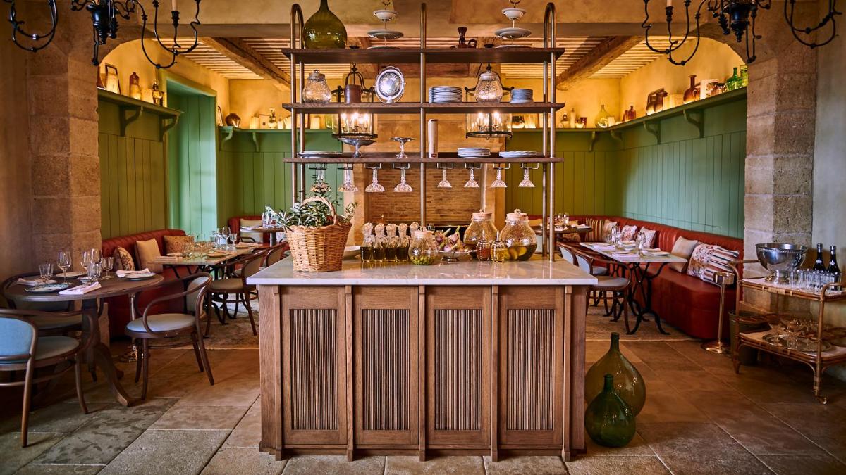 un restaurant avec des tables et des chaises et un bar dans l'établissement Airelles Gordes, La Bastide, à Gordes