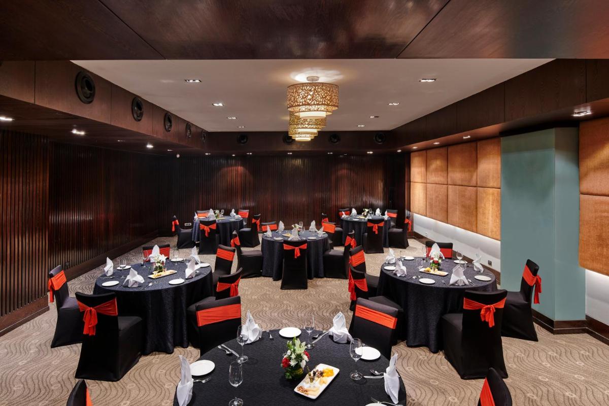 a conference room with tables and chairs and a chandelier at Holiday Inn Mumbai International Airport by IHG in Mumbai