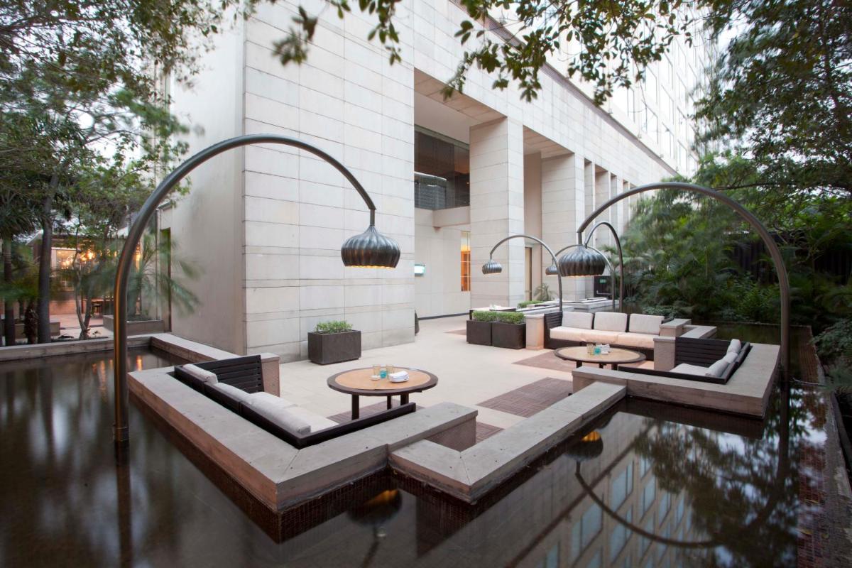 a pool with chairs and tables in a building at Hyatt Regency Amritsar Hotel & Spa in Amritsar