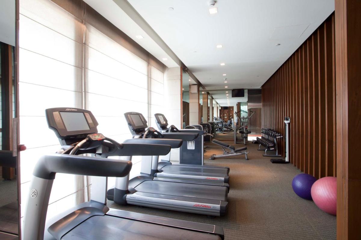 a gym with rows of treadms and cardio machines at Hyatt Regency Amritsar Hotel & Spa in Amritsar