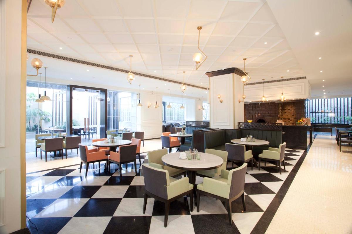 a restaurant with tables and chairs on a checkered floor at Hyatt Regency Amritsar Hotel & Spa in Amritsar