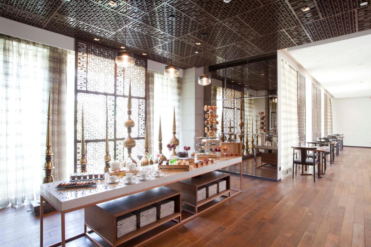 a large room with tables and chairs and windows at Hyatt Regency Amritsar Hotel & Spa in Amritsar