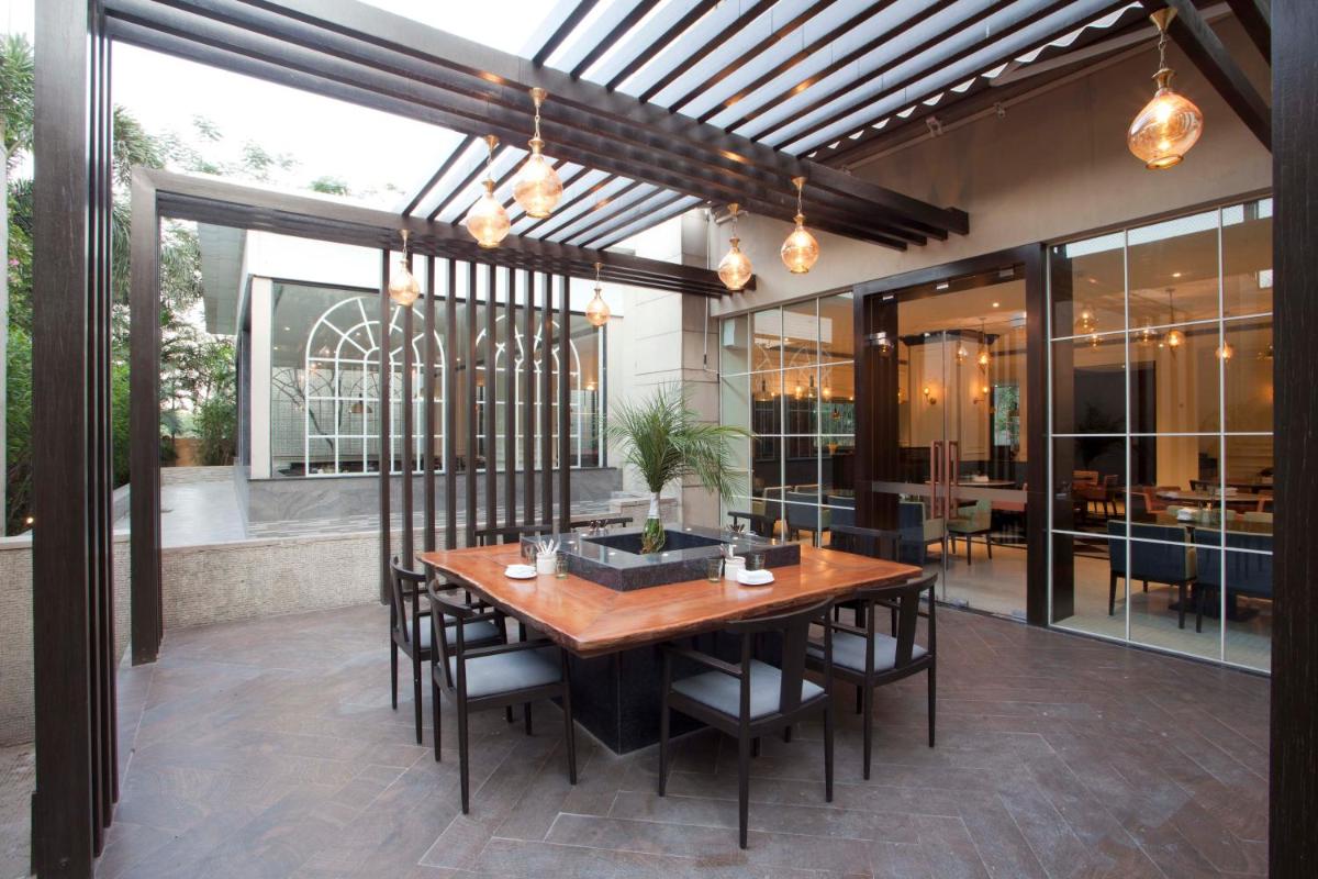 a dining room with a wooden table and chairs at Hyatt Regency Amritsar Hotel & Spa in Amritsar
