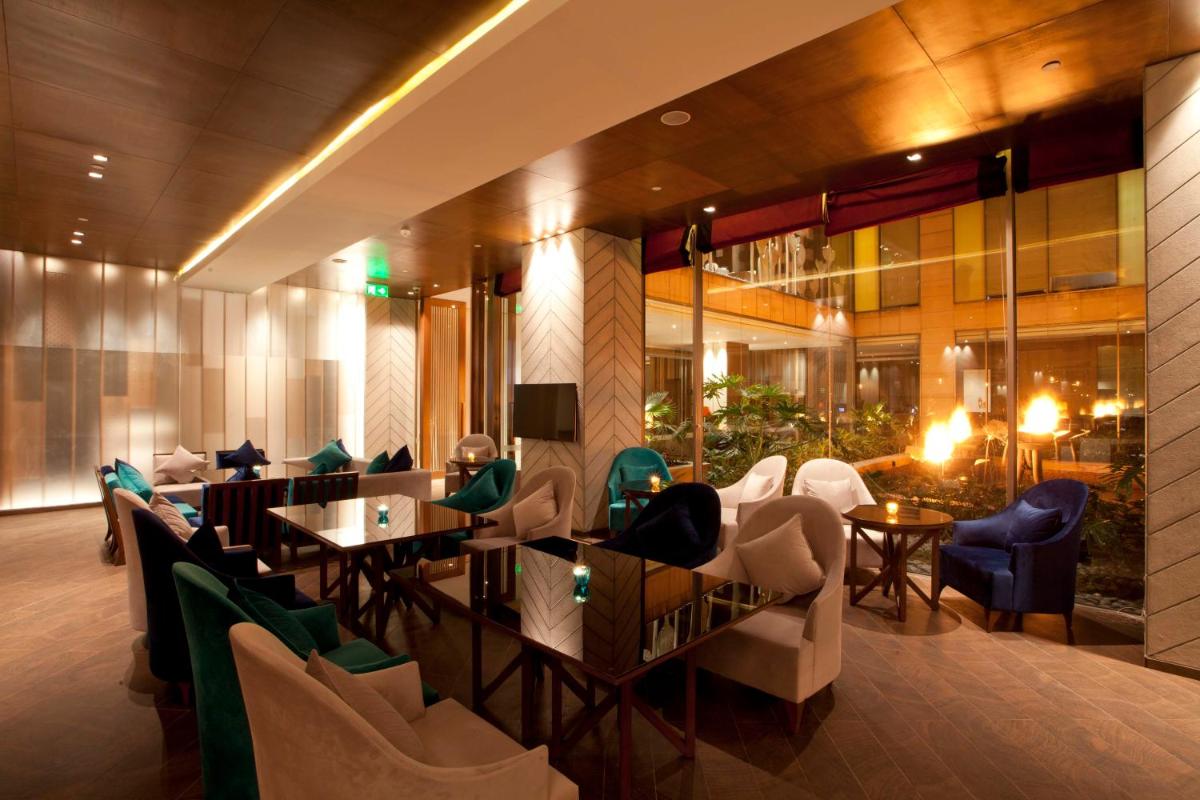 a restaurant with tables and chairs in a building at Hyatt Regency Amritsar Hotel & Spa in Amritsar
