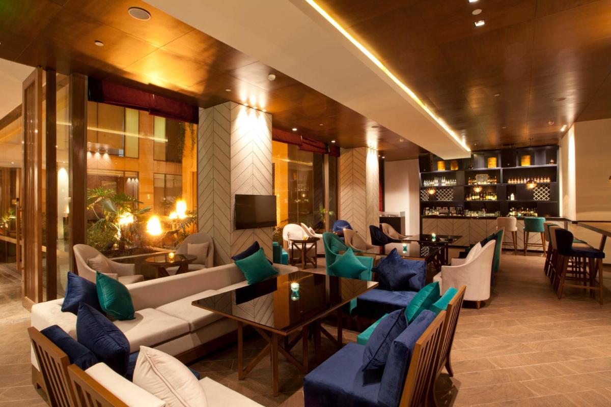 a lobby with a couch and chairs and a table at Hyatt Regency Amritsar Hotel & Spa in Amritsar
