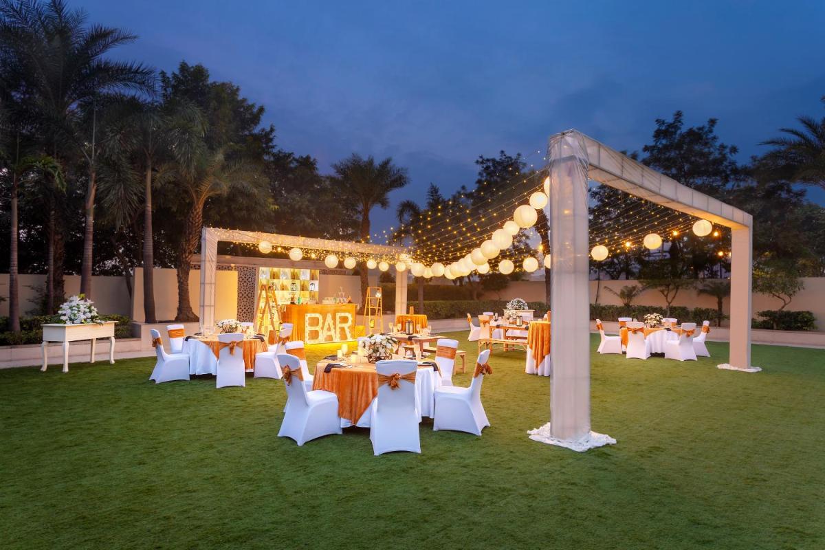 a group of tables and chairs in a field with lights at Hyatt Regency Amritsar Hotel & Spa in Amritsar +76 photos