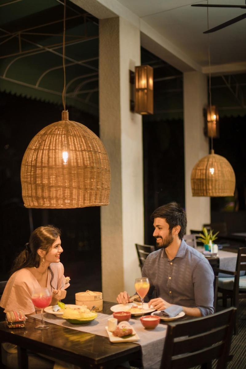 a man and woman sitting at a table in a restaurant at Hyatt Hyderabad Gachibowli in Hyderabad