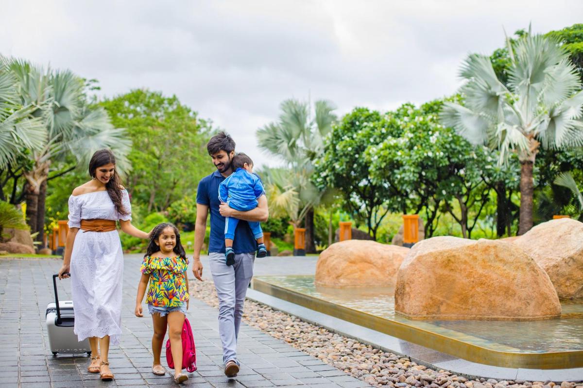 a family walking through a park with their child at Hyatt Hyderabad Gachibowli in Hyderabad