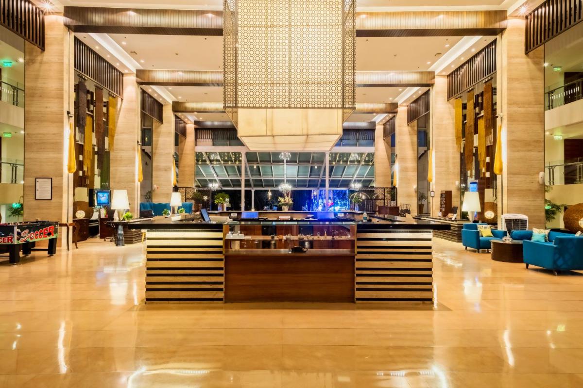 a lobby with a bar in the middle of a building at Novotel Goa Candolim in Candolim a lobby with a bar in the middle of a building at Novotel Goa Candolim in Candolim