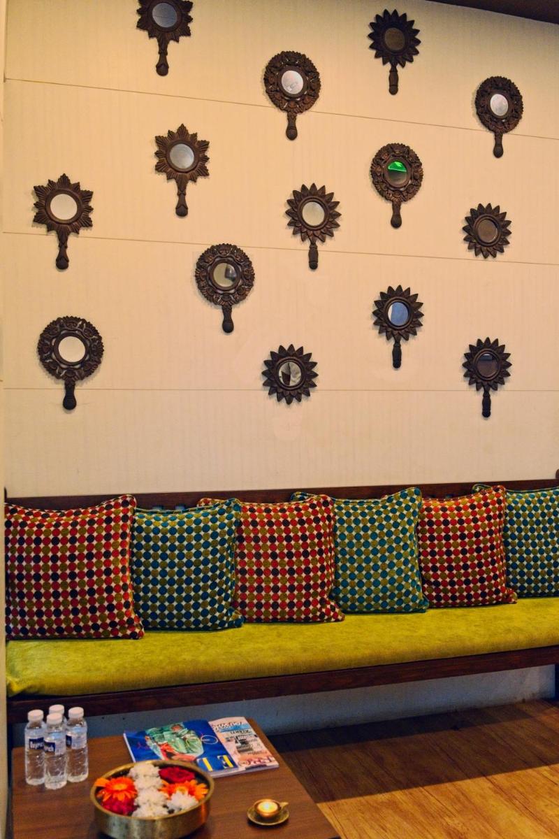 a bench with pillows against a wall with clocks at Novotel Goa Candolim in Candolim a bench with pillows against a wall with clocks at Novotel Goa Candolim in Candolim