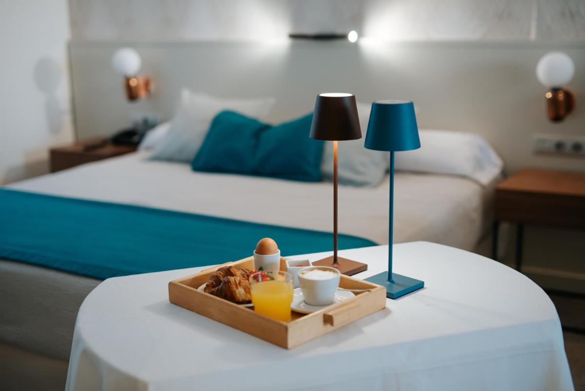 Cama o camas de una habitación en Hotel Neptuno Playa & Spa