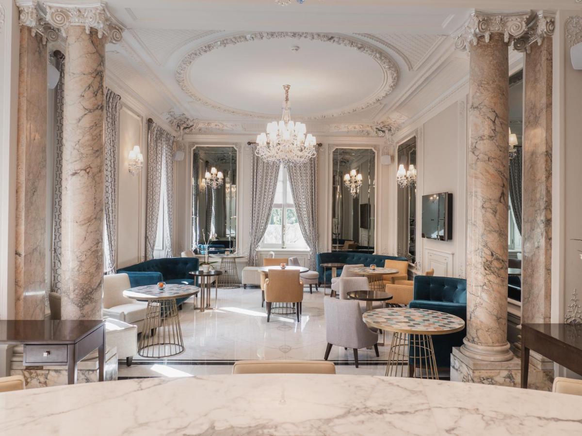 un hall avec des tables, des chaises et un lustre dans l'établissement Villa Genesis, à Menton
