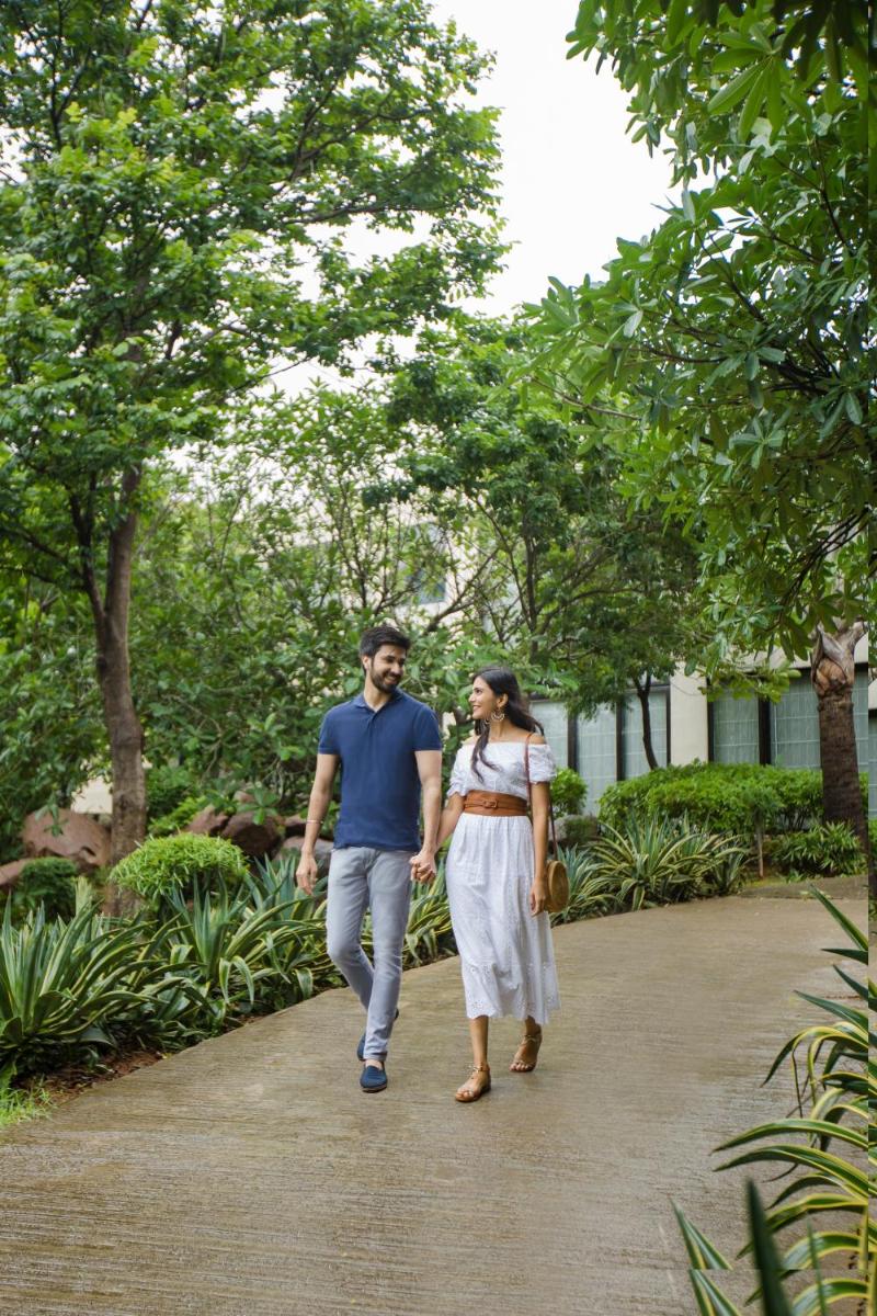 a man and a woman walking down a path at Hyatt Hyderabad Gachibowli in Hyderabad