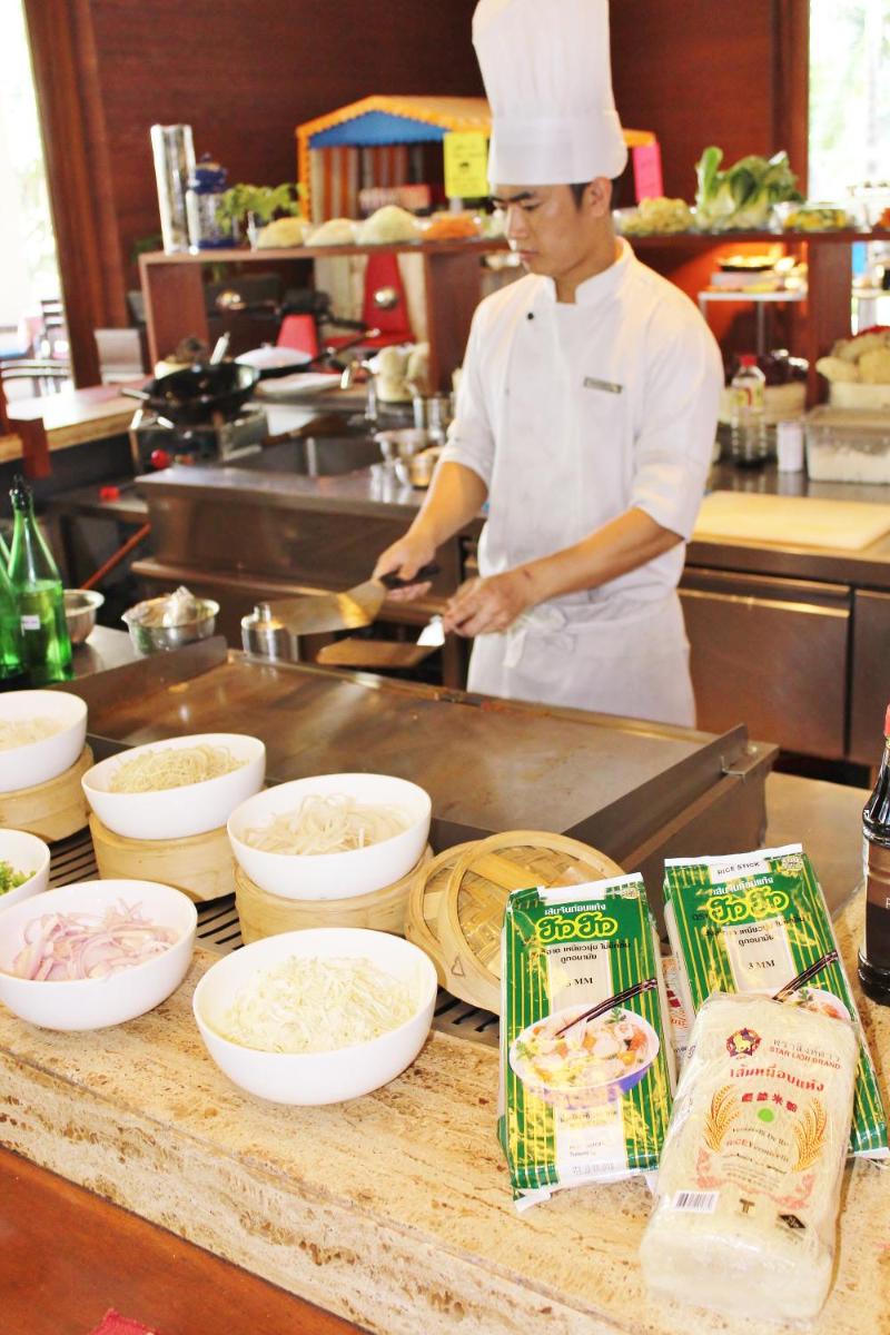 a chef preparing food in a kitchen with ingredients at Hyatt Hyderabad Gachibowli in Hyderabad