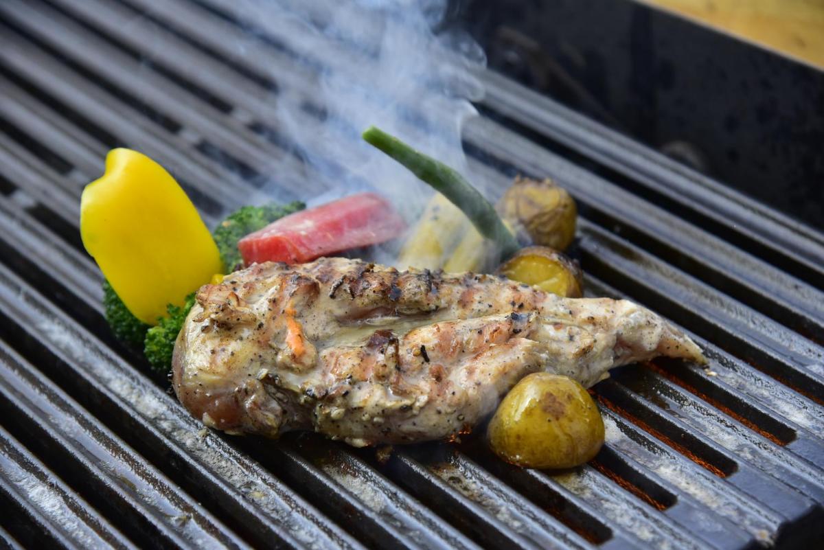 a piece of meat and vegetables on a grill at Novotel Ahmedabad in Ahmedabad