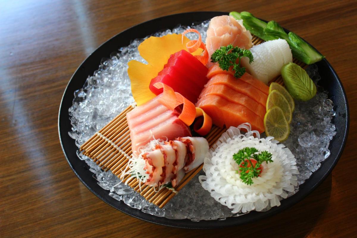 a plate with sushi and rice on a table at Novotel Ahmedabad in Ahmedabad