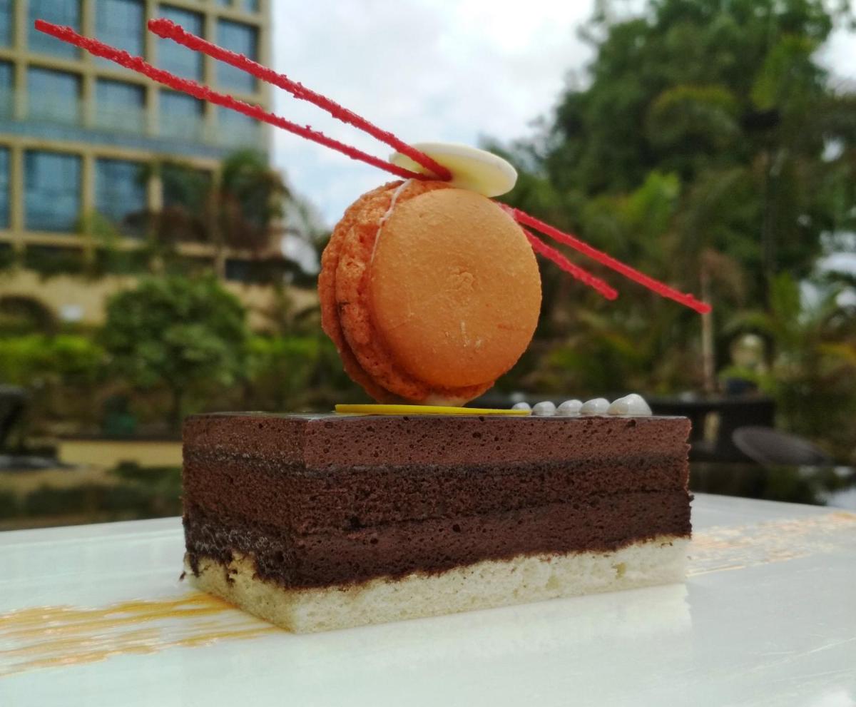 a piece of chocolate cake sitting on top of a table at Novotel Ahmedabad in Ahmedabad
