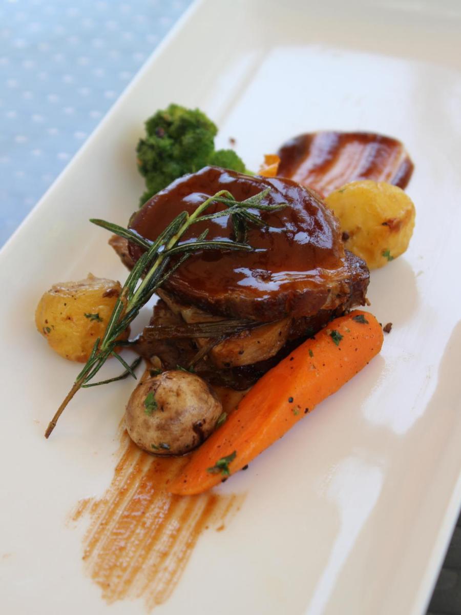 a plate of food with meat and potatoes and carrots at Novotel Ahmedabad in Ahmedabad