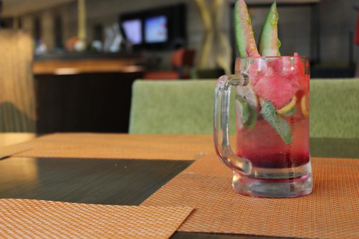 a glass vase filled with a drink on a table at Novotel Ahmedabad in Ahmedabad