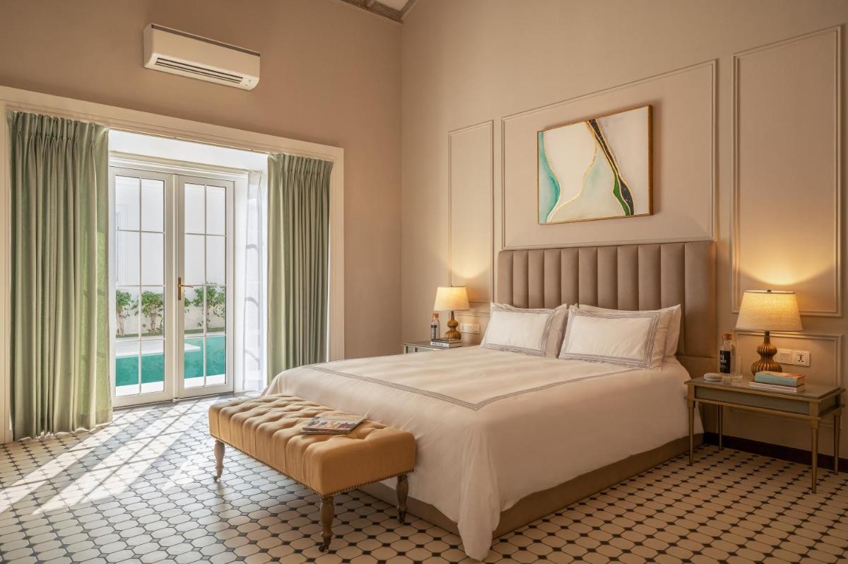 a bedroom with a large bed and a large window at MansionHaus in Anjuna