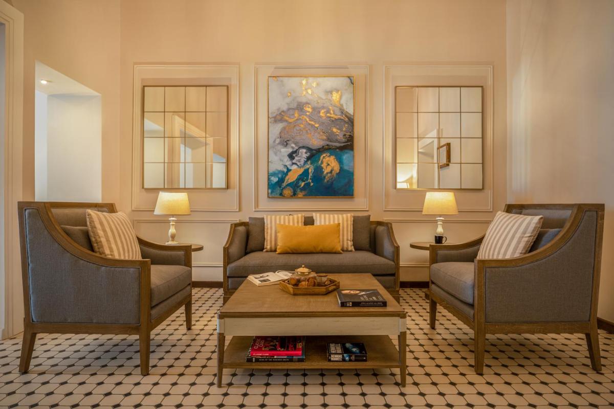 a living room with a couch and two chairs at MansionHaus in Anjuna