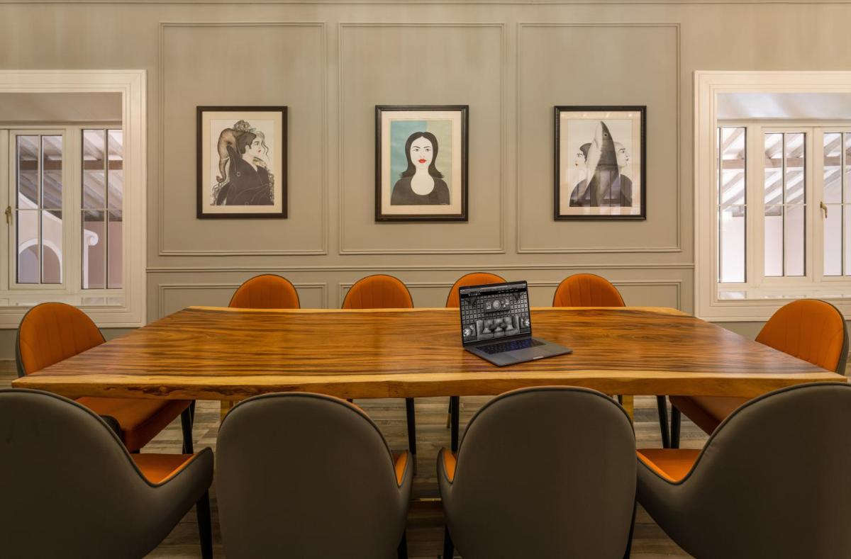 a conference room with a table with a laptop on it at MansionHaus in Anjuna