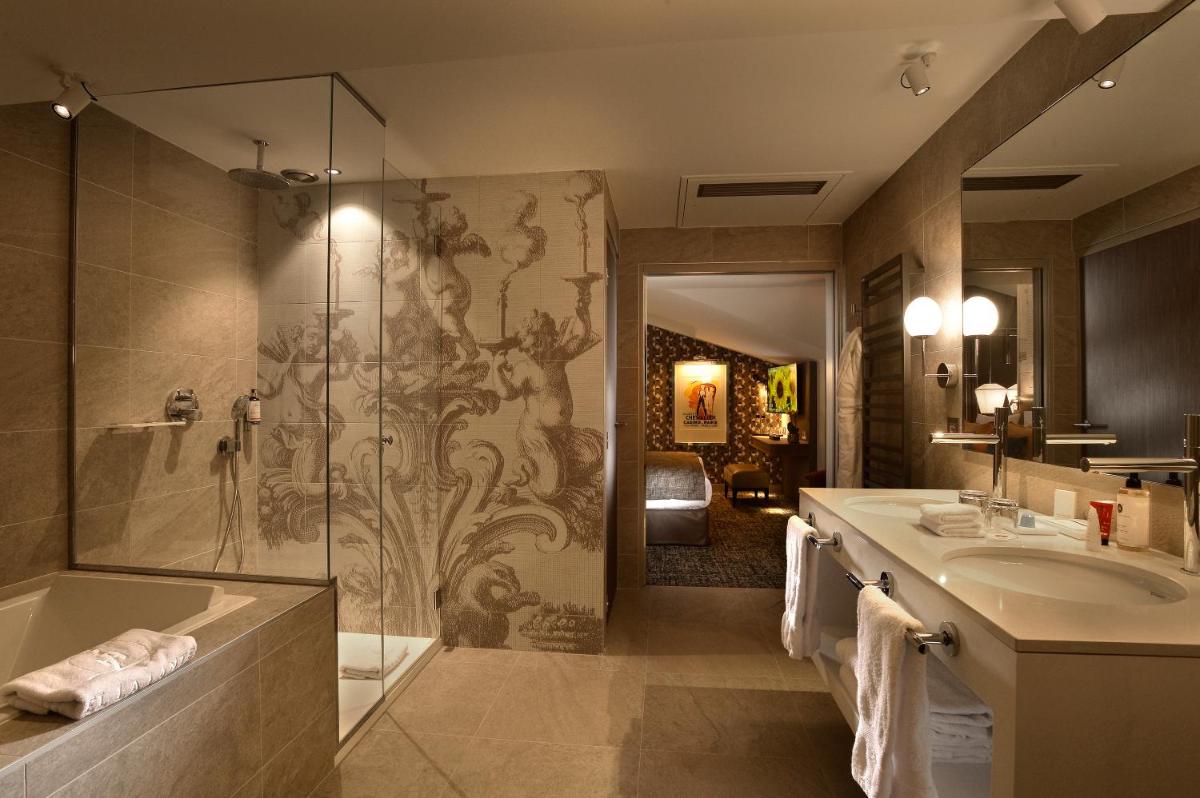une salle de bain avec douche, baignoire et lavabo dans l'établissement Hotel La Lanterne & Spa By Timhotel, à Paris