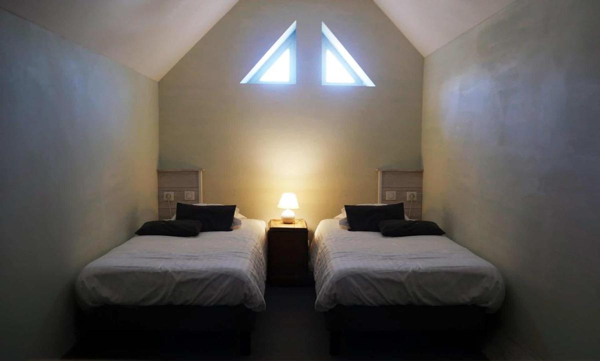 Un ou plusieurs lits dans un hébergement de l'établissement Hôtel Le Dormeur