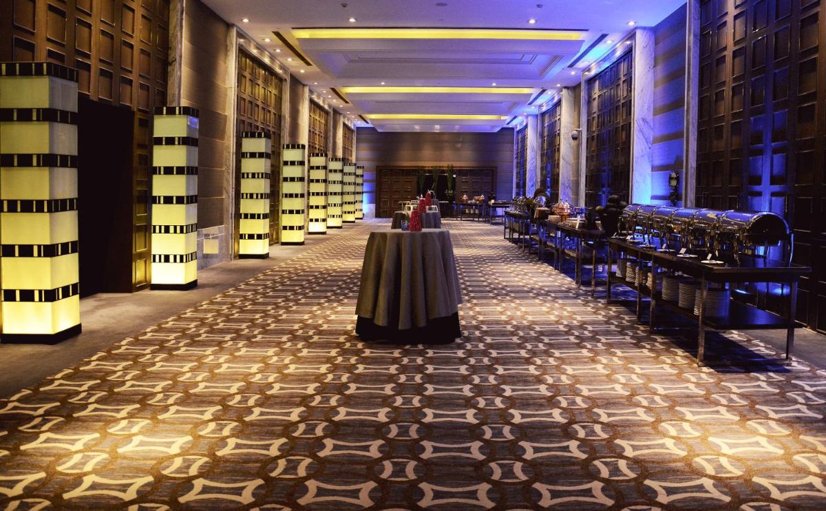 a long hallway with a table in the middle of a building at Hyatt Regency Gurgaon in Gurgaon