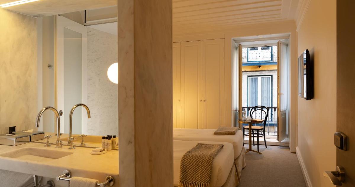 um banheiro com cama, pia e espelho em Lisboa Pessoa Hotel em Lisboa