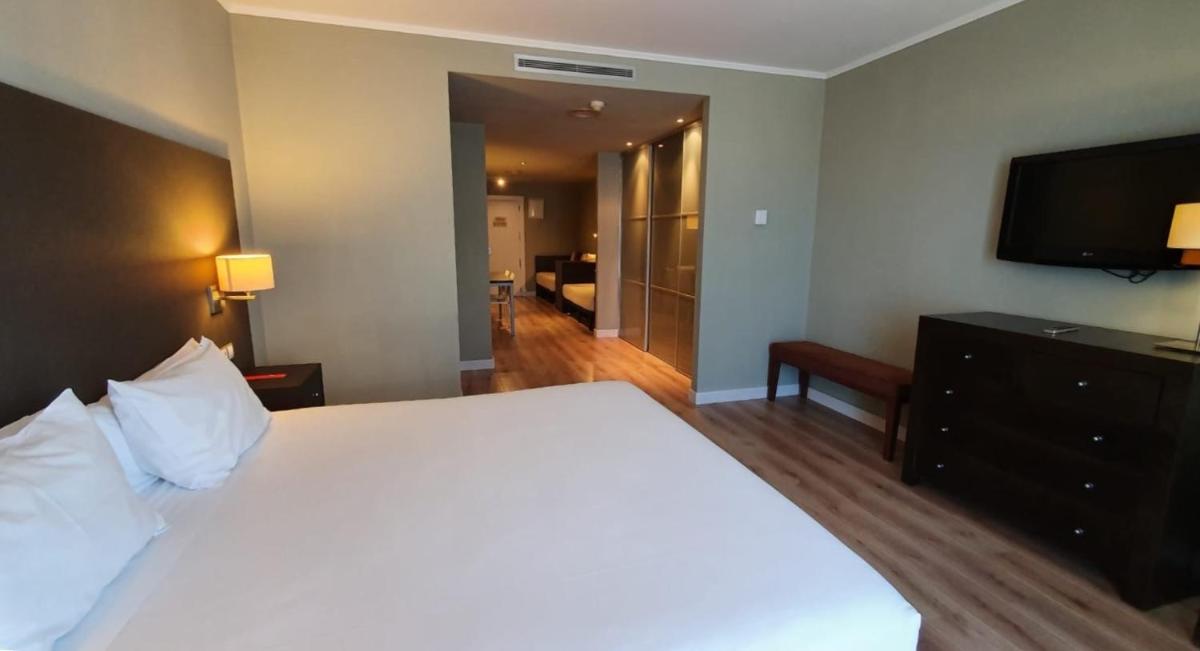 Un dormitorio con una cama grande y un televisor de pantalla plana. en HG La Molina, en La Molina